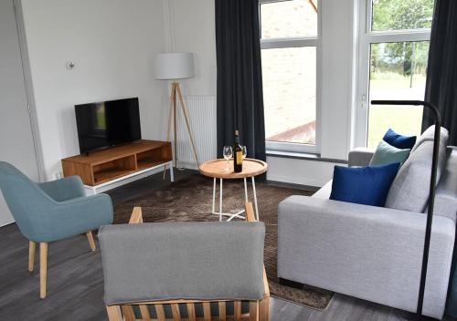 a living room with a couch and a table and a tv at Waterdorp Burdaard in Burdaard