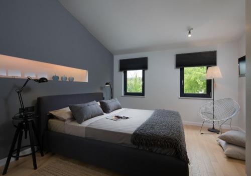 Un dormitorio con una cama grande y dos ventanas. en Villa Storia near Rabac, en Labin