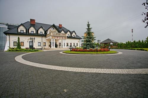 a building with a curvy road in front of it at Zajazd Dworek in Mircze