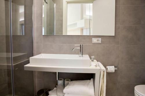 uma casa de banho com um lavatório e um espelho em Lungotevere Suite em Roma