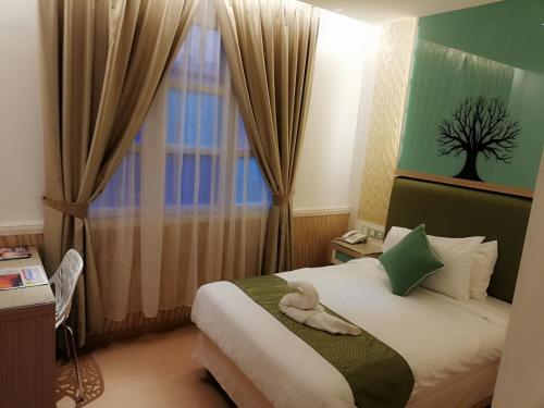 a hotel room with a bed and a window at Holiday Place Kuala Lumpur in Kuala Lumpur
