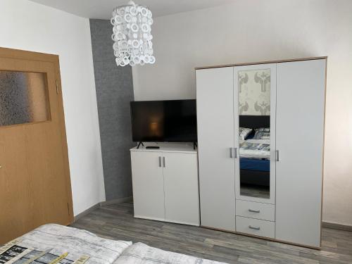 アンベルク・ブッフホルツにあるFerienwohnung Anger 2の白い大きなキャビネット(テレビ付)が備わるベッドルーム1室が備わります。