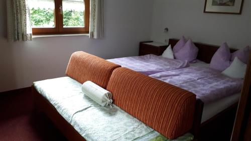 a bedroom with a bed with an orange blanket on it at Gästehaus Hedwig in Bad Hindelang