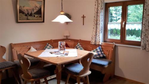 a dining room with a wooden table and chairs at Gästehaus Hedwig in Bad Hindelang