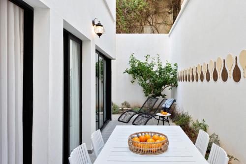 a basket of oranges on a table on a patio at Mr. Ben Yehuda - By TLV2GO in Tel Aviv