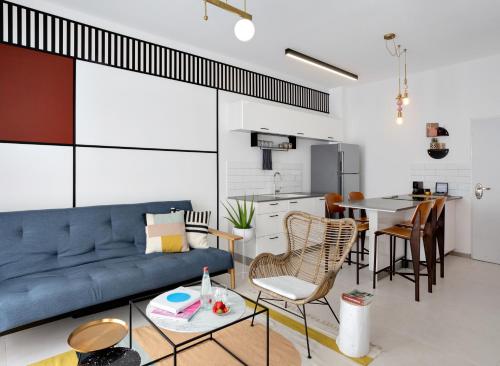 a living room with a blue couch and a table at Mr. Ben Yehuda - By TLV2GO in Tel Aviv