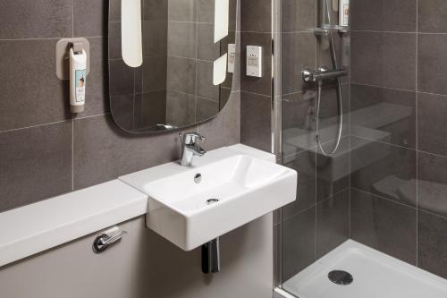 La salle de bains est pourvue d'un lavabo et d'une douche. dans l'établissement ibis Coventry South, à Coventry