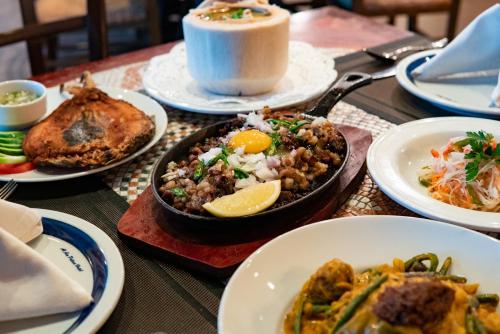 a table with plates of food and a cup of coffee at Al Ain Palace Hotel Abu Dhabi in Abu Dhabi