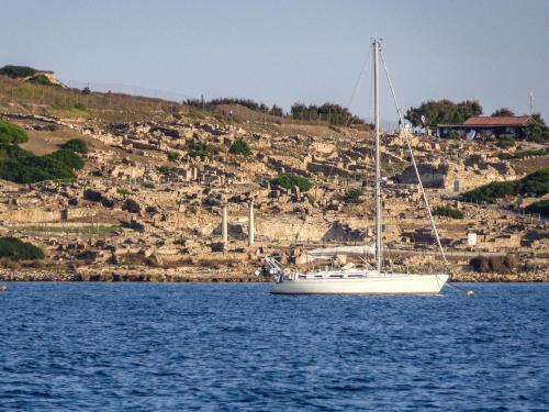 a sailboat on the water with a hill in the background at Il Quarzo in Càbras