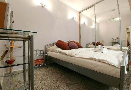 a bedroom with a bed with a mirror on the wall at Apartament Oficyna in Krakow