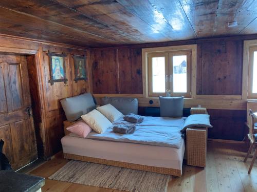 a bed in a room with wooden walls at Klösterle 72 -Annas Lodge in Klösterle am Arlberg