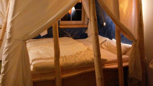 a small bed with a canopy in a room at Kunsthof Eibenstock in Eibenstock