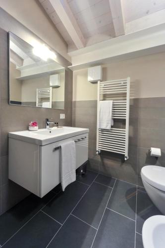 a bathroom with a sink and a toilet and a mirror at Belvivere Suites in Sona