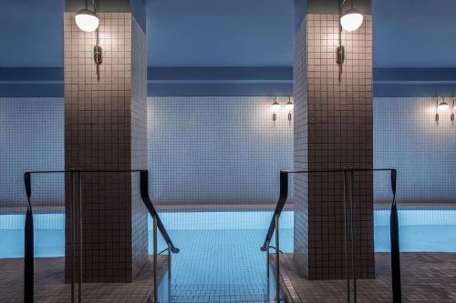 uma piscina com duas colunas altas e uma piscina em Hôtel du Rond-point des Champs-Élysées - Esprit de France em Paris