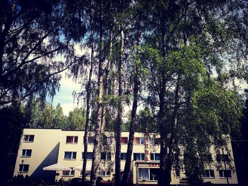 a white building with trees in front of it at Minhauzena Unda in Saulkrasti
