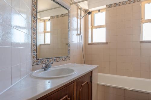 e bagno con lavandino, specchio e vasca. di Villa Nora by Gabi Miguel ad Albufeira