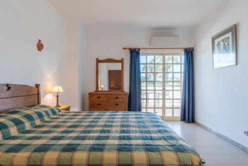 ein Schlafzimmer mit einem Bett, einer Kommode und einem Fenster in der Unterkunft Villa Nora by Gabi Miguel in Albufeira