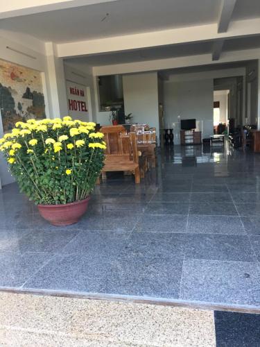 a lobby with a pot of yellow flowers on the floor at khách sạn Ngân Hà in Tuy Hoa