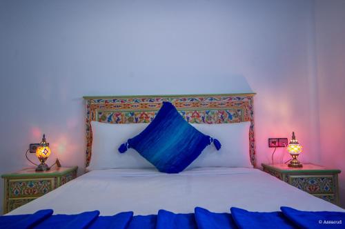 a bedroom with a bed with a blue pillow on it at Puerta Azul in Chefchaouene