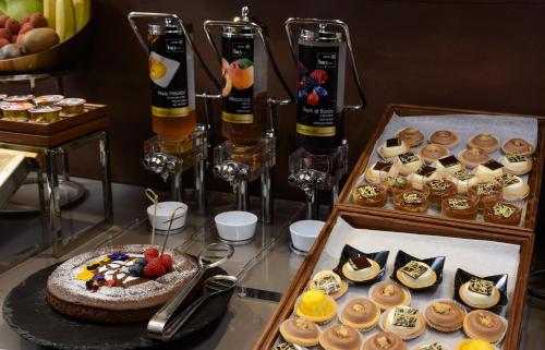 a buffet of desserts and drinks on a table at Hotel Metropolitan in Bologna