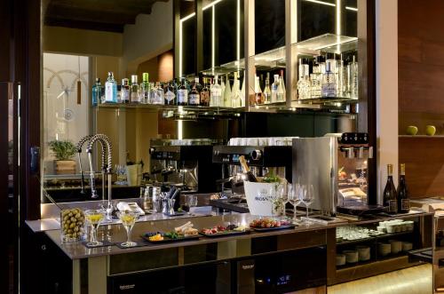 a kitchen with a bar with food and wine glasses at Hotel Metropolitan in Bologna