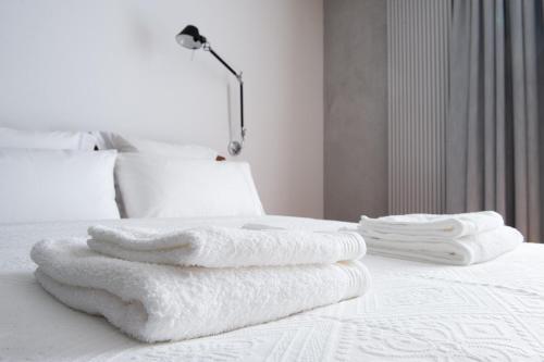 a pile of towels sitting on top of a bed at eswiety10 in Poznań