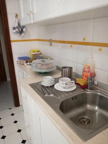 a kitchen sink with two cups and plates on it at B&B A Casa Dei Nonni in Capua
