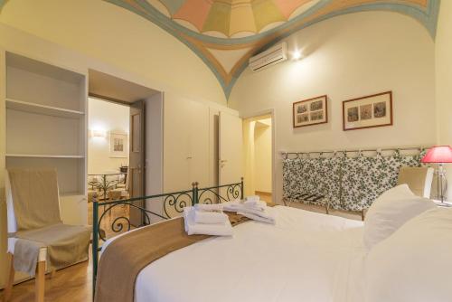 a bedroom with a large bed and a chair at Casa Cornacchie - FromHometoRome in Rome