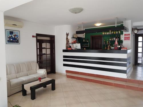 a room with a bar with a couch and a table at Pensiunea Roua in Piatra Neamţ