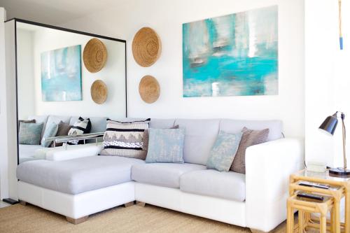 a living room with a white couch and paintings at Dreamy Sea View Accommodation Gran Canaria in San Agustin