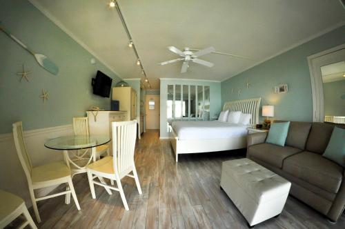a bedroom and living room with a bed and a table at Cove Inn on Naples Bay in Naples