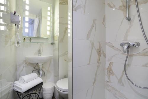 a bathroom with a shower and a toilet and a sink at Hotel Suisse in Strasbourg