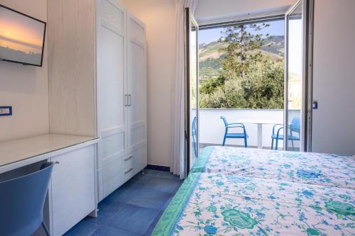 ein Schlafzimmer mit einem Bett und einem großen Fenster in der Unterkunft Casa Vacanze Parco Del Generale in Ischia