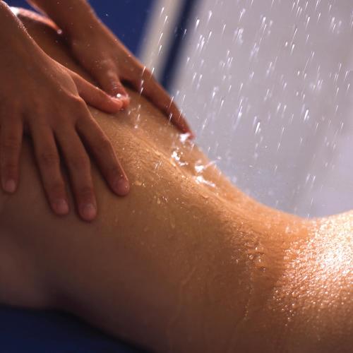 a woman is washing her back with a shower at Thalacap Camargue in Saintes-Maries-de-la-Mer
