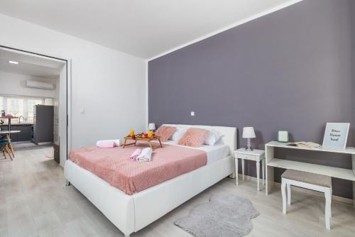 a white bedroom with a bed and a desk at Apartment Lucia in Rijeka