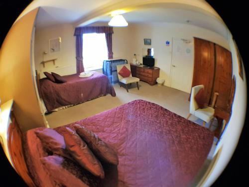 a room with a bed, a chair, and a mirror at White House Country Inn in Sennybridge
