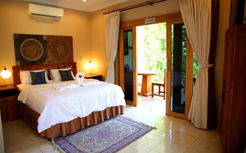 A bed or beds in a room at Villa Alba Bali Dive Resort