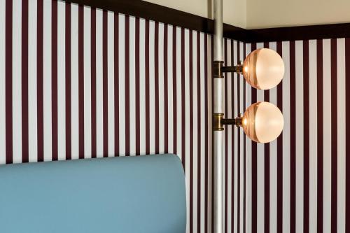 a bedroom with red and white striped walls and a bed at Hôtel du Rond-point des Champs-Élysées - Esprit de France in Paris