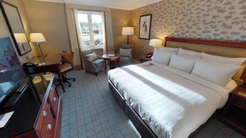 a hotel room with a large bed and a desk at Dalmahoy Hotel & Country Club in Edinburgh