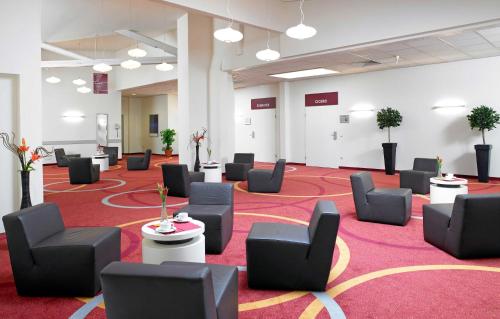 a large room with chairs and tables on a red carpet at B&K Hotels in Vlotho