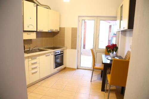 a kitchen with white cabinets and a table and a kitchen at Dioniss Apartment in Sibiu
