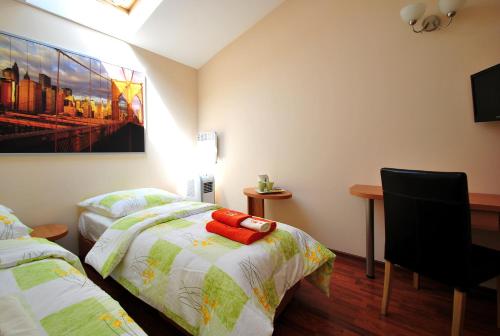 a room with two beds and a desk in it at AL-Tour in Gdynia