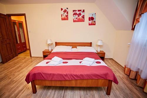 a bedroom with a large bed with a red blanket at Zajazd Dworek in Mircze