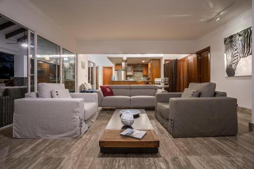 ein Wohnzimmer mit zwei Sofas und einem Couchtisch in der Unterkunft Balcones Beach Penthouse in Las Terrenas