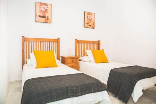 two beds sitting next to each other in a room at Apartamento Las Chapas - bonito y tranquilo in Marbella