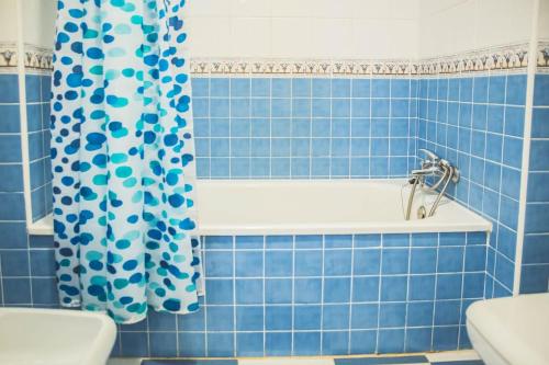 a blue tiled bathroom with a tub and a shower curtain at Apartamento Las Chapas - bonito y tranquilo in Marbella