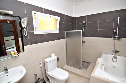ein Badezimmer mit einem weißen WC und einem Waschbecken in der Unterkunft Les Residences MAMOUNE in Dakar