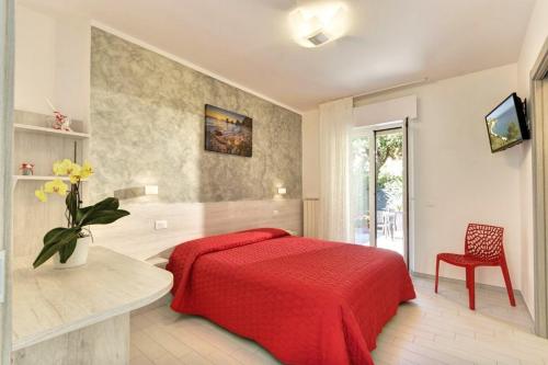 a bedroom with a red bed and a vase of flowers at Affittacamere I Principi del Conero in Numana