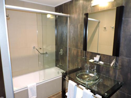 uma casa de banho com um chuveiro, um lavatório e uma banheira em Regency Park Hotel em Montevidéu