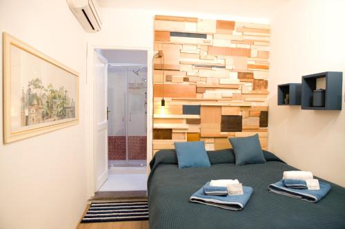 1 dormitorio con 1 cama y pared de madera en Private Modern Studio Paolina City Center, en Roma